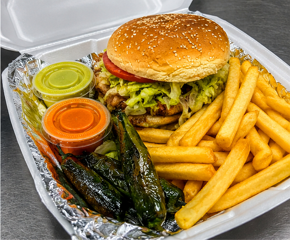 Hawaiian burger on sesame seed bun with lettuce, tomato, fries, and chiles toreados